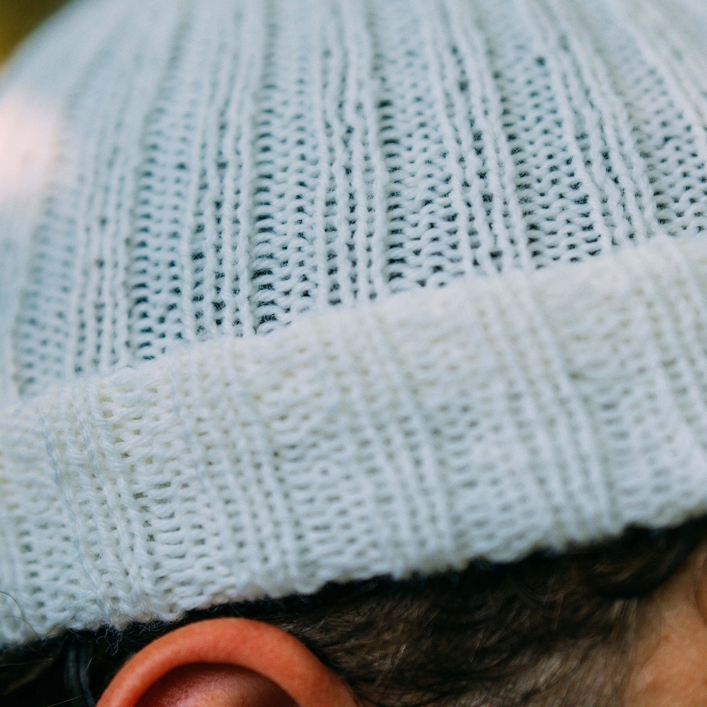 Hand knit wool beanie, white, close up