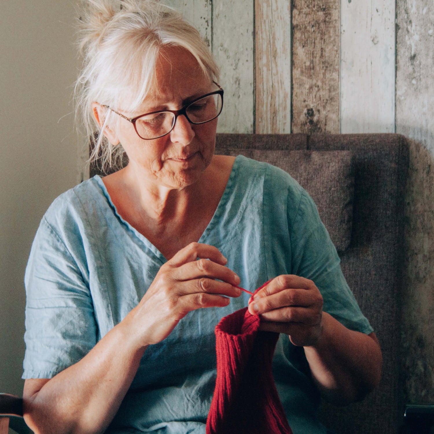 Woman knitting red wool beanie